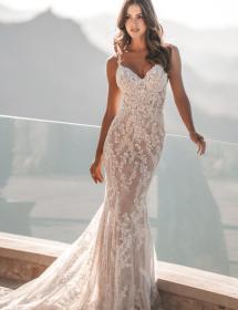 Beautiful model next to a glass wall modeling Allure style 1204 wedding dress
