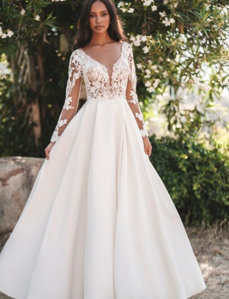 Plus size model wearing a stunning wedding dress in front of trees.