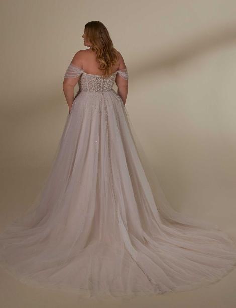 Plus size model wearing a stunning wedding dress with her back to you to show off the back.