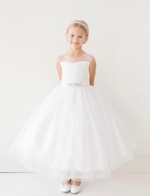 Little girl modeling a white puffy flower girl dress in front of a white wall