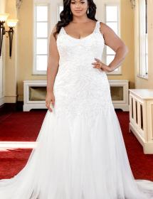 Plus size model wearing a beautiful wedding dress on a red carpet in an ornate room