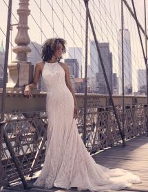 Model wearing a wedding dress on a New York bridge with the city in the background. Could be Chicago.