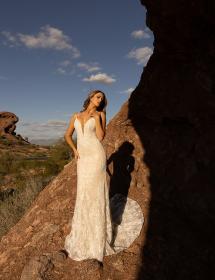Happy model wearing a wedding gown in a desert with a steep canyon in the background. Don't fall!